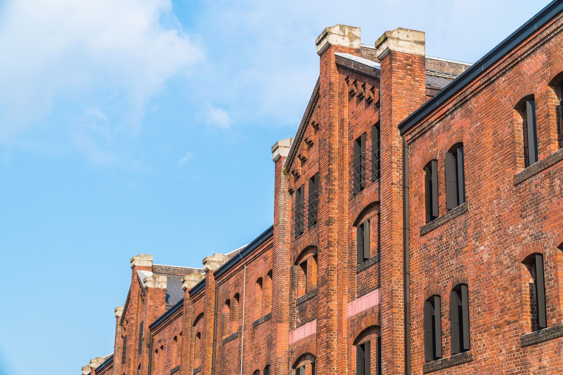 a row of red brick buildings against a blue sky