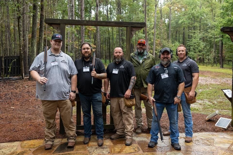 A group of men are posing for a picture in the woods.