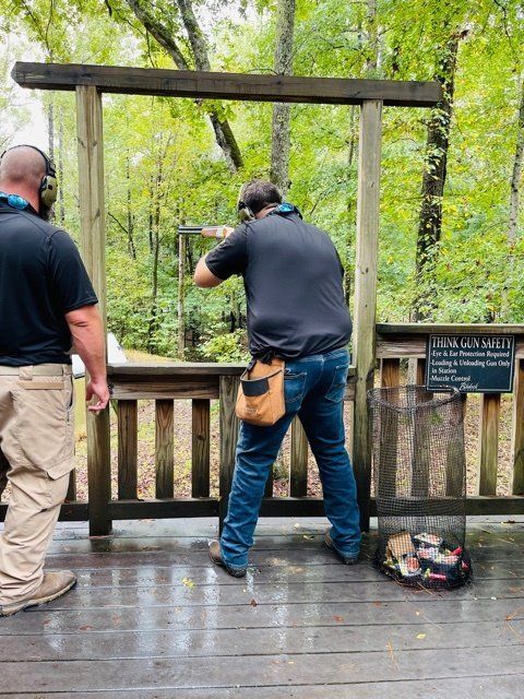 Two men are standing next to each other on a wooden deck.