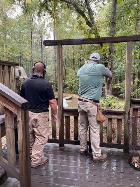Two men are standing on a deck looking out over a body of water.