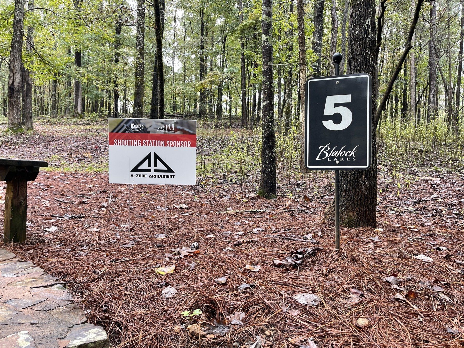 A sign in the middle of a forest with the number 5 on it.