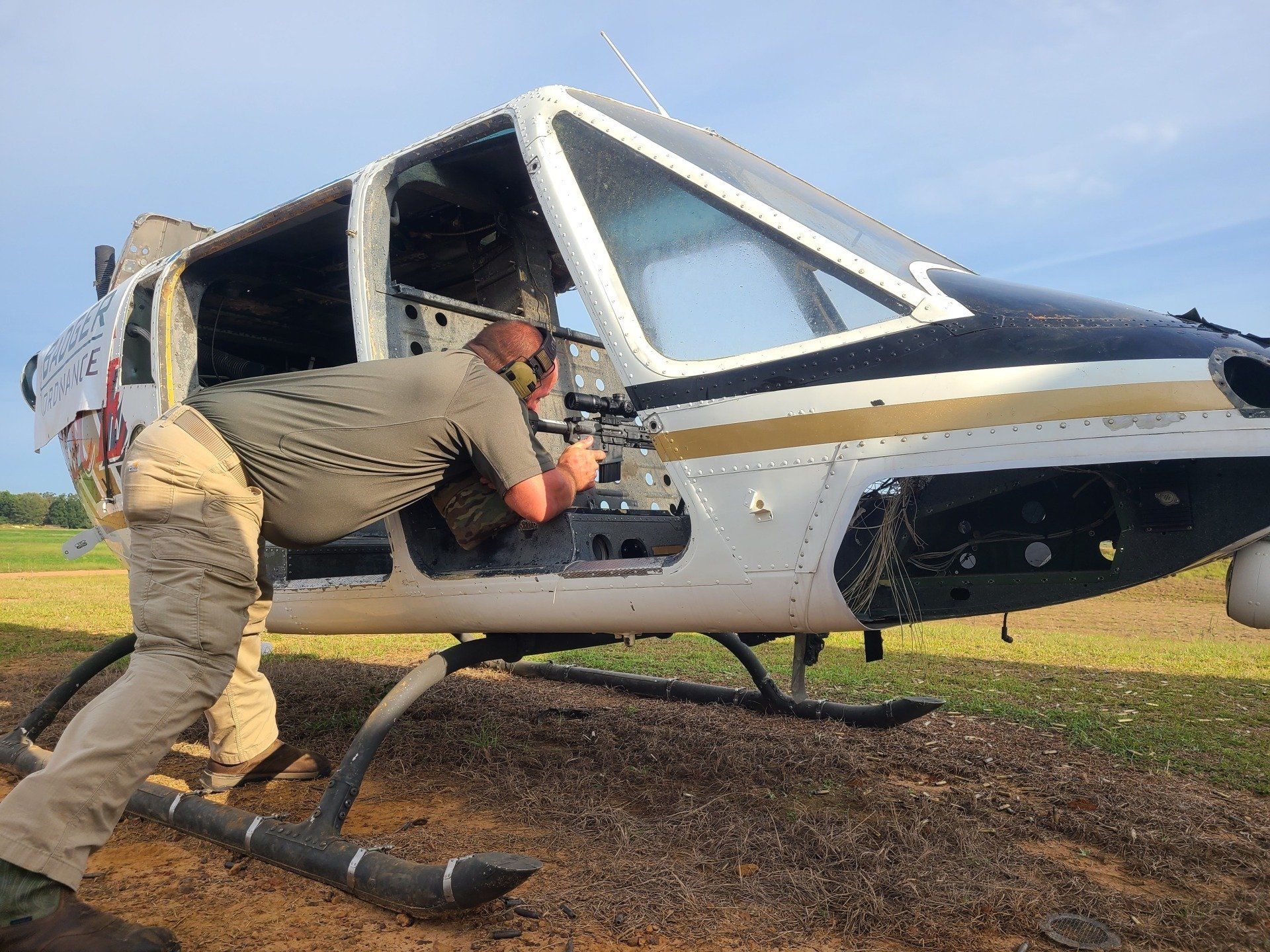 A man is getting out of a helicopter in a field