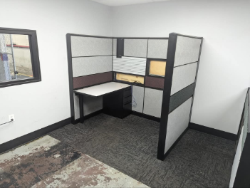 An office cubicle with a desk and a window
