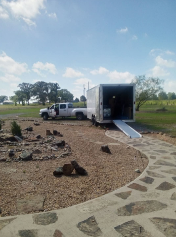 A white truck is parked next to a white trailer