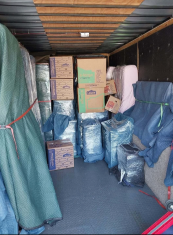 The inside of a moving truck filled with boxes and blankets