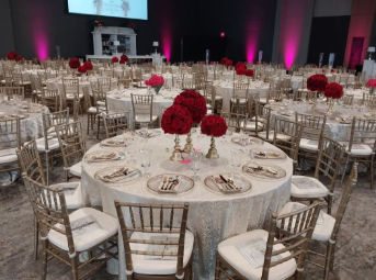 A large room with tables and chairs set up for a wedding reception.