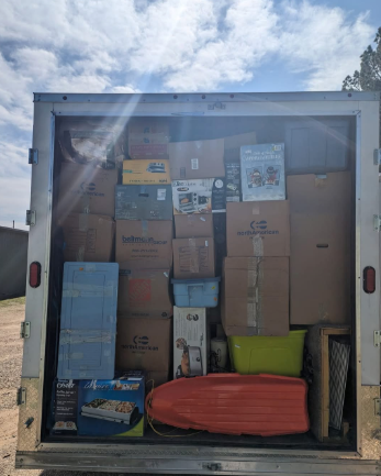 The back of a trailer filled with boxes and toys.