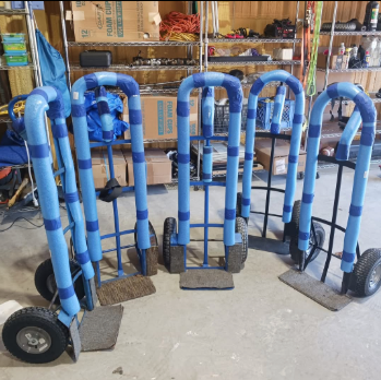 A bunch of blue carts are lined up in a garage