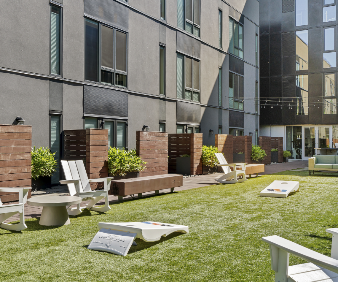 A lawn with chairs and tables in front of a building