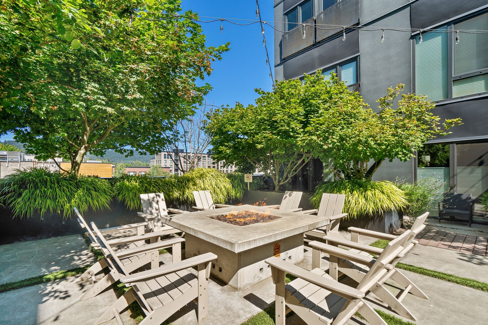 A patio with a table and chairs and a fire pit.