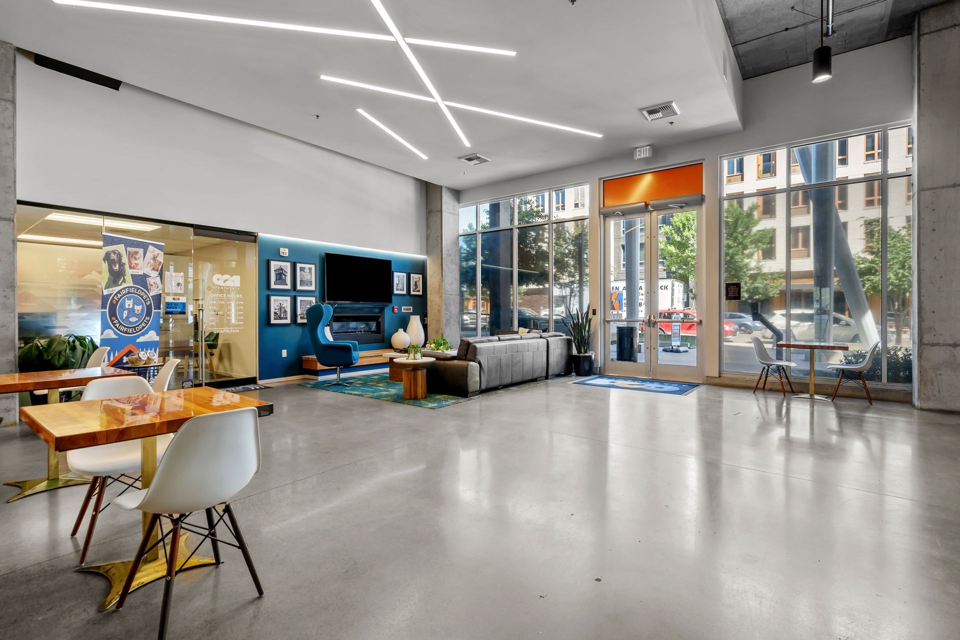 A large room with a lot of windows and tables and chairs.