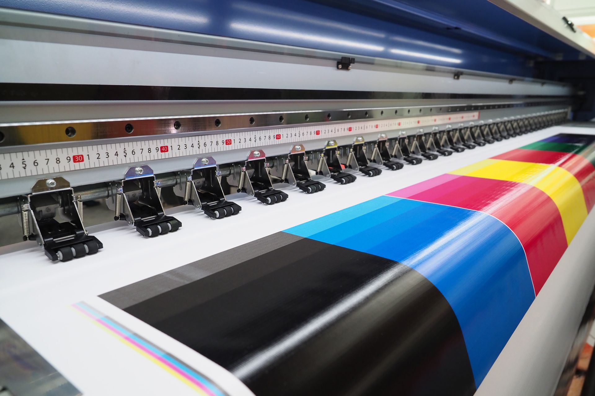 Large format printer in operation, printing a color test strip.