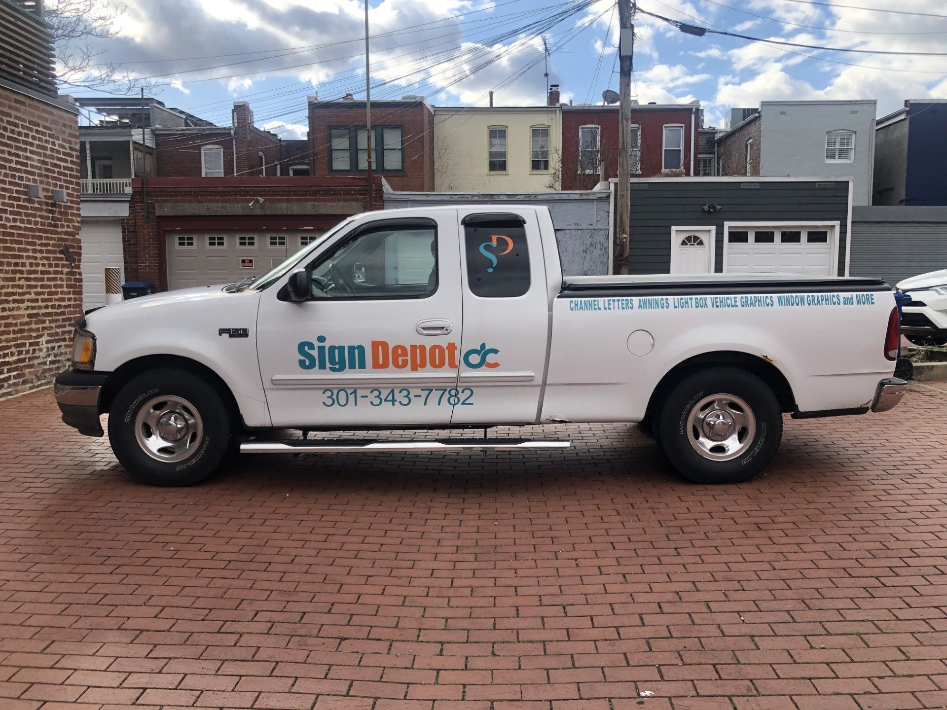 Sign for a Winter Market with buildings in the background. It reads 
