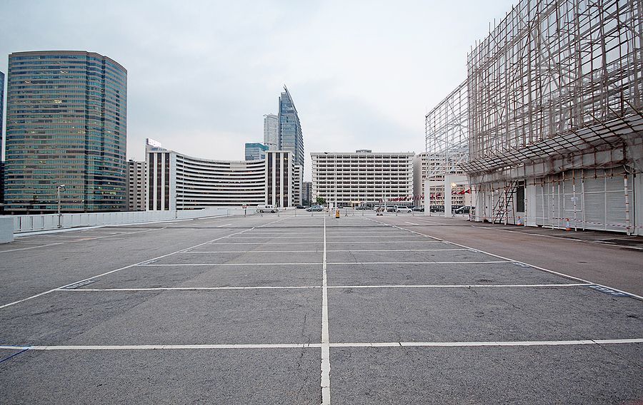 An empty parking lot with a city skyline in the background.