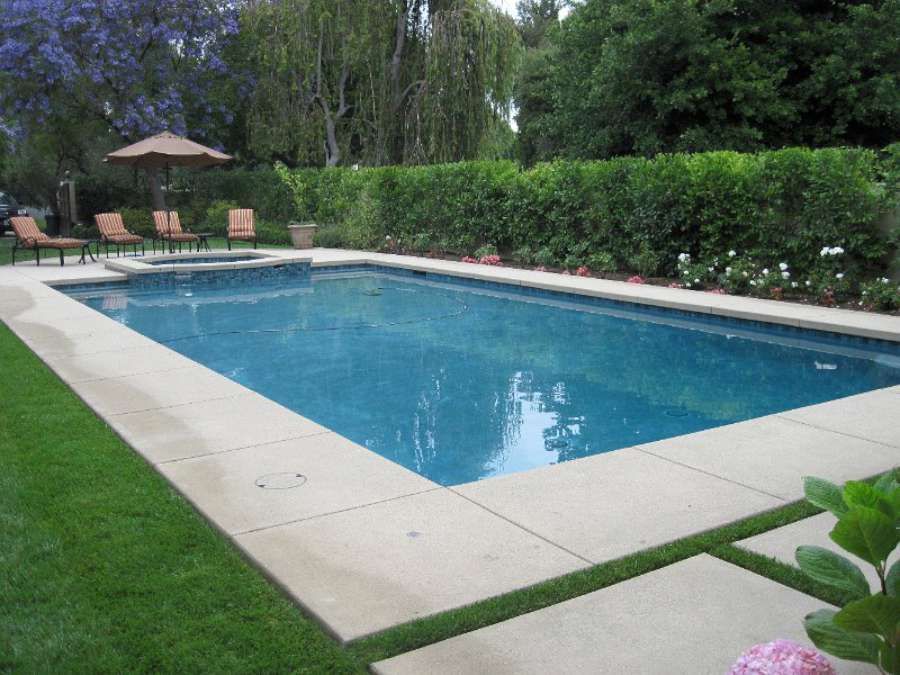 A large swimming pool with chairs and umbrellas around it