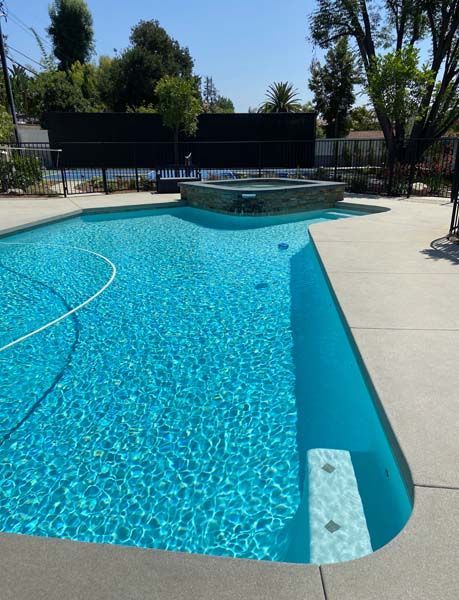 A large swimming pool with a basketball court in the background