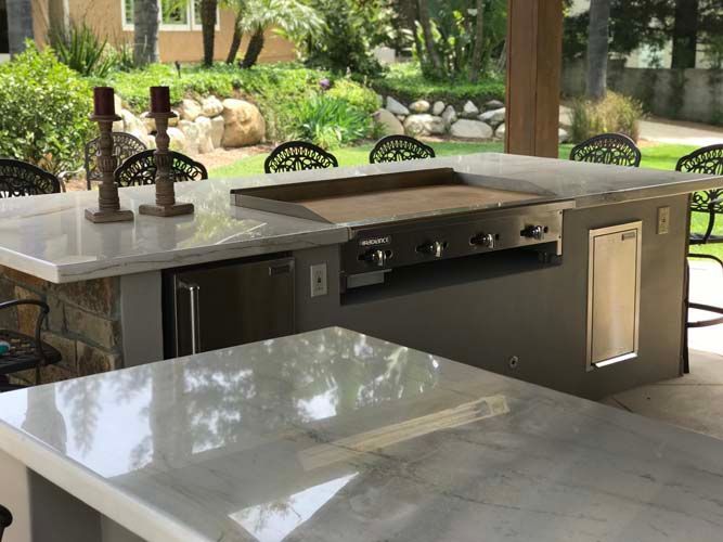 There is a grill on the counter in the kitchen.