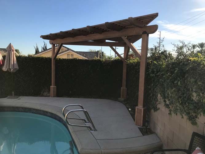 A swimming pool with a wooden pergola over it