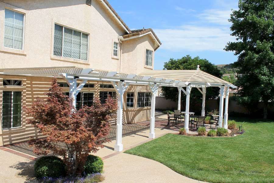 An outdoor kitchen with a fireplace and a flat screen tv.