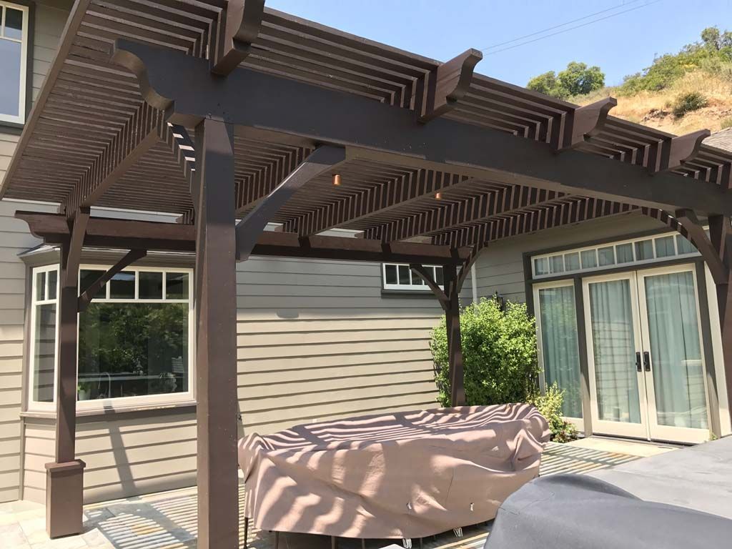 An outdoor kitchen with a fireplace and a flat screen tv.