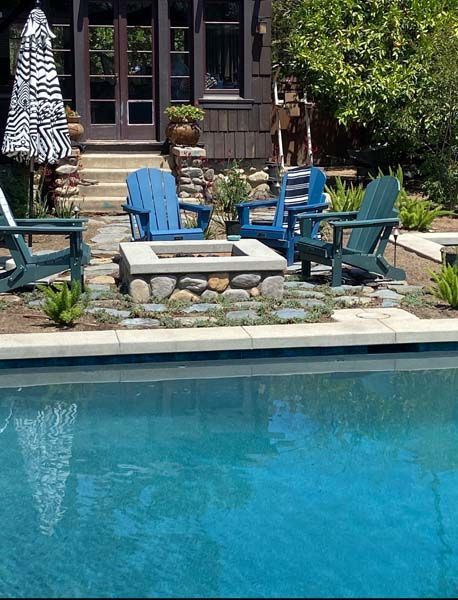 An outdoor kitchen with a fireplace and a flat screen tv.