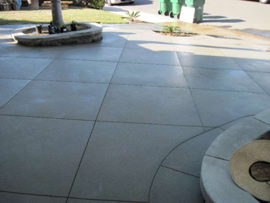 A patio with a fire pit and a tree in the background