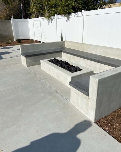 A concrete patio with a fire pit in the middle