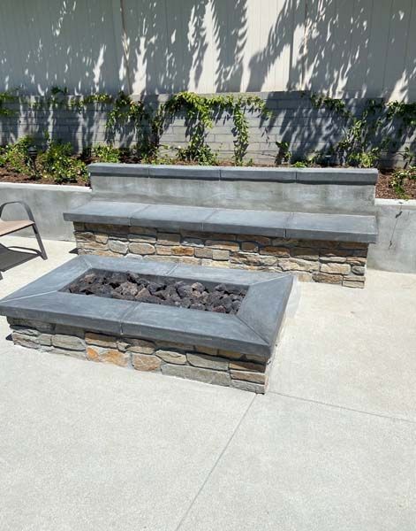 An outdoor kitchen with a fireplace and a flat screen tv.