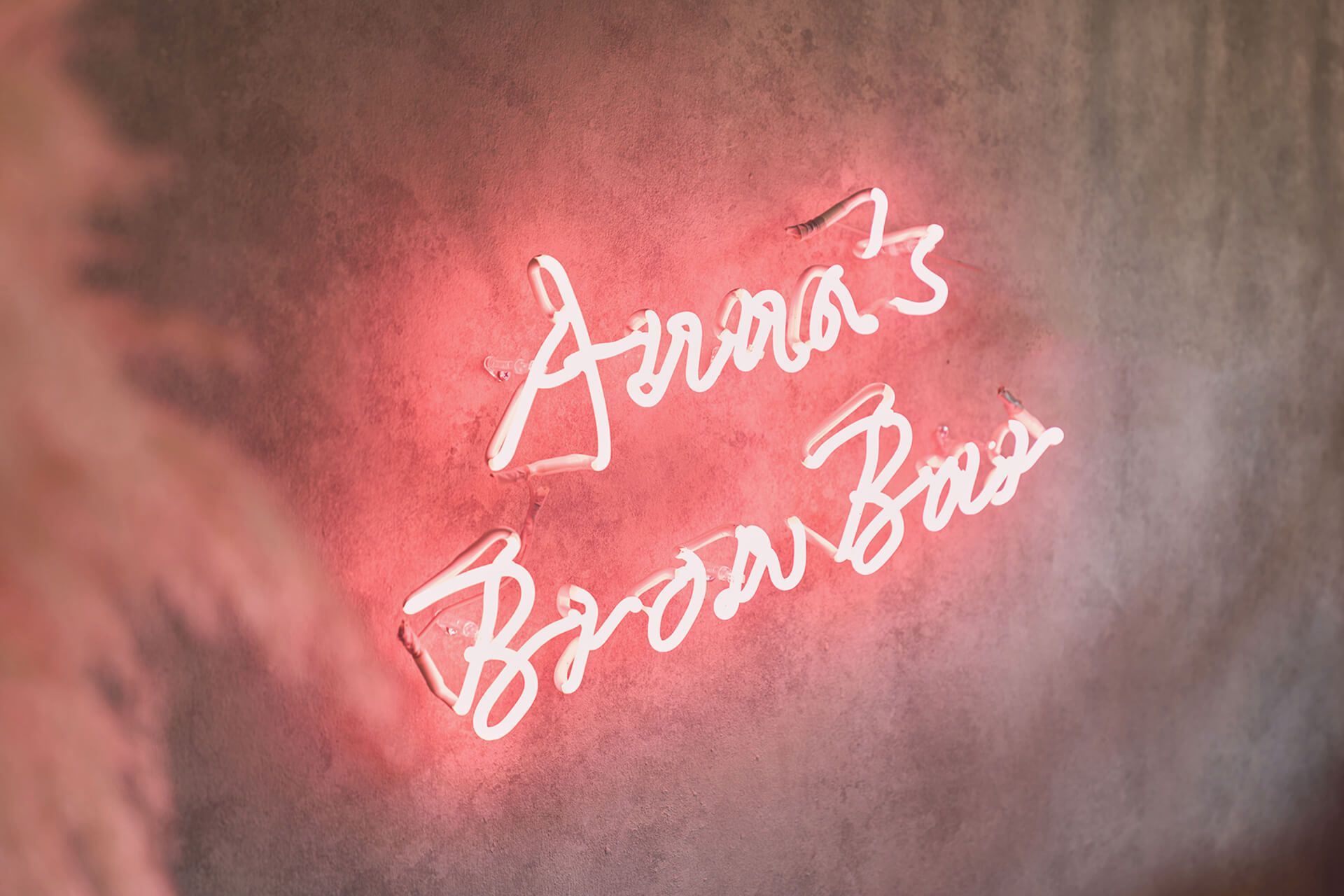 A close up of a neon sign that says anna 's brow bar.