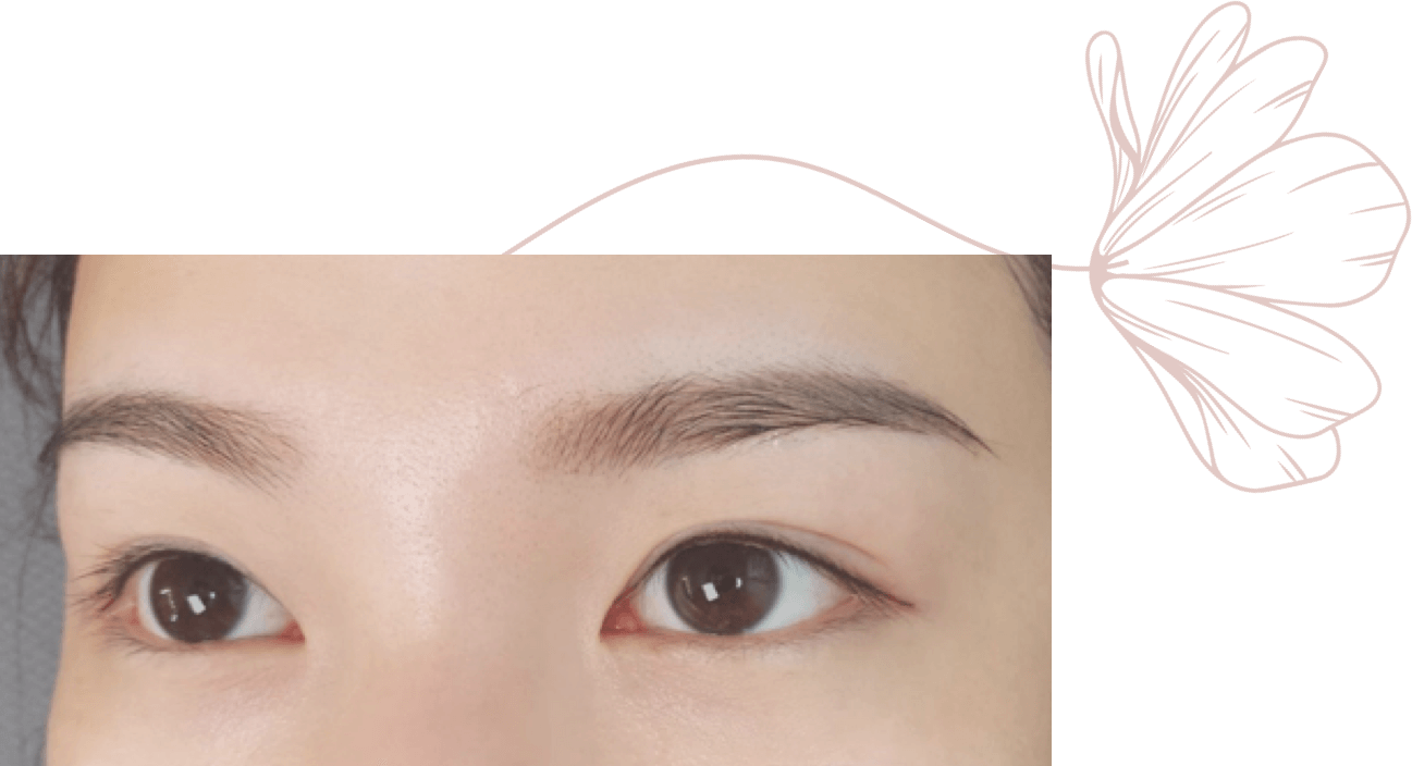 A close up of a woman 's eyes with a flower in the background.