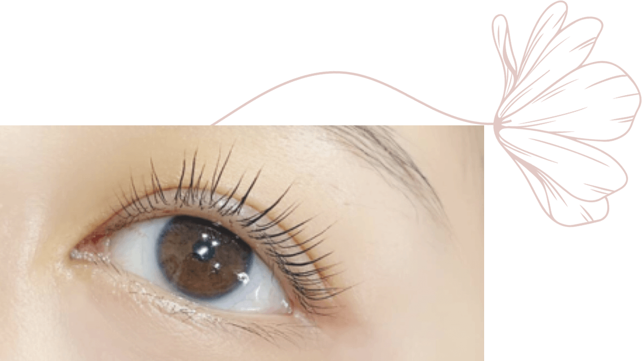 A close up of a woman 's eye with a flower in the background.