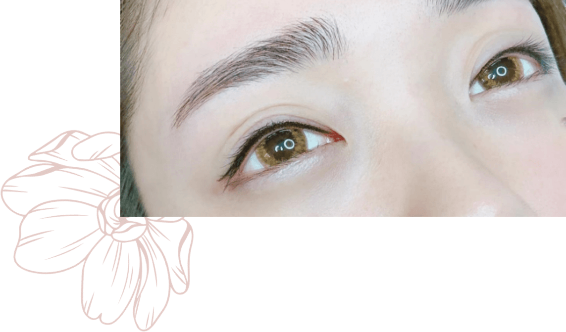 A close up of a woman 's eyes with a flower in the background.