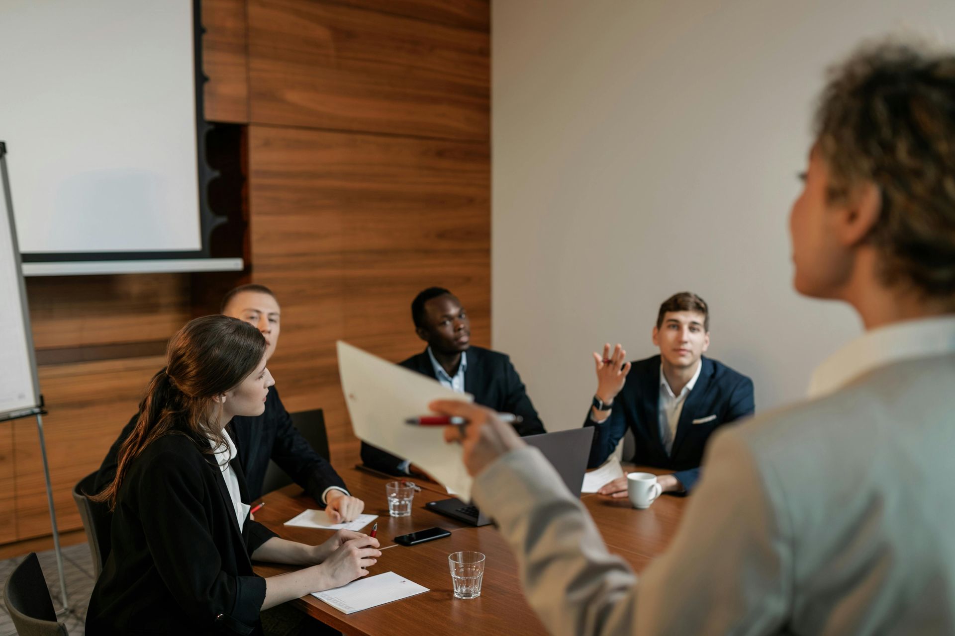 A woman is giving a presentation to a group of people in a conference room.