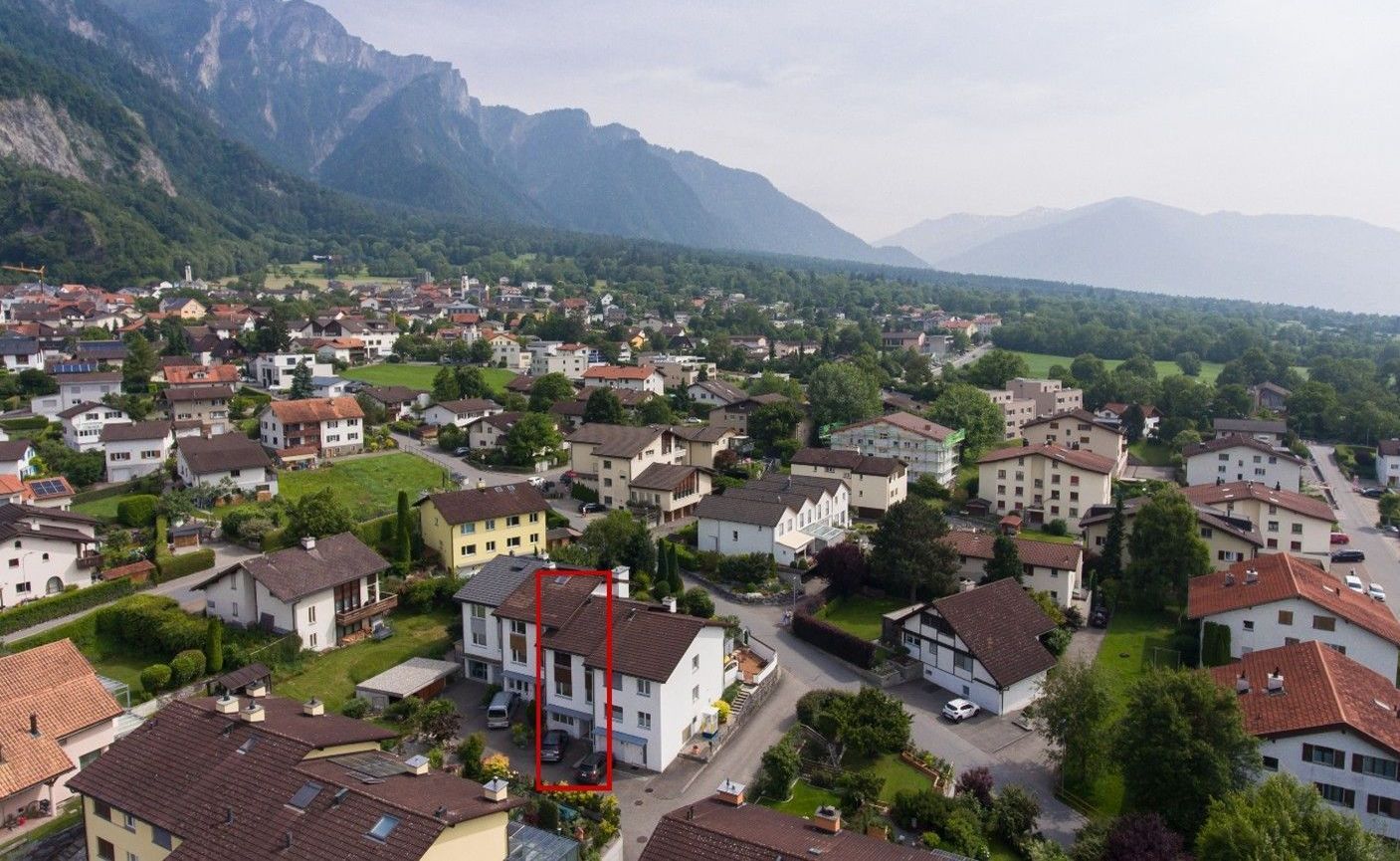 Eine Luftaufnahme einer kleinen Stadt mit Bergen im Hintergrund