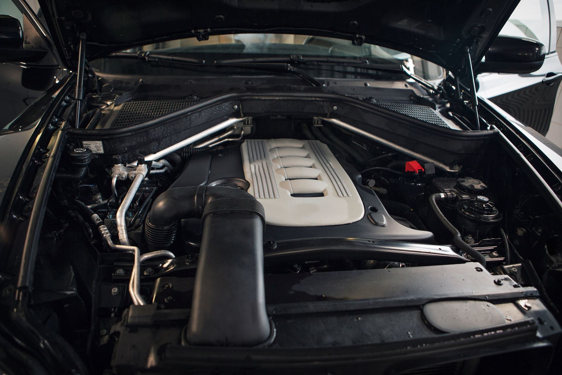 Car repair and cleaning concept - car engine close-up, wiping parts under the hood