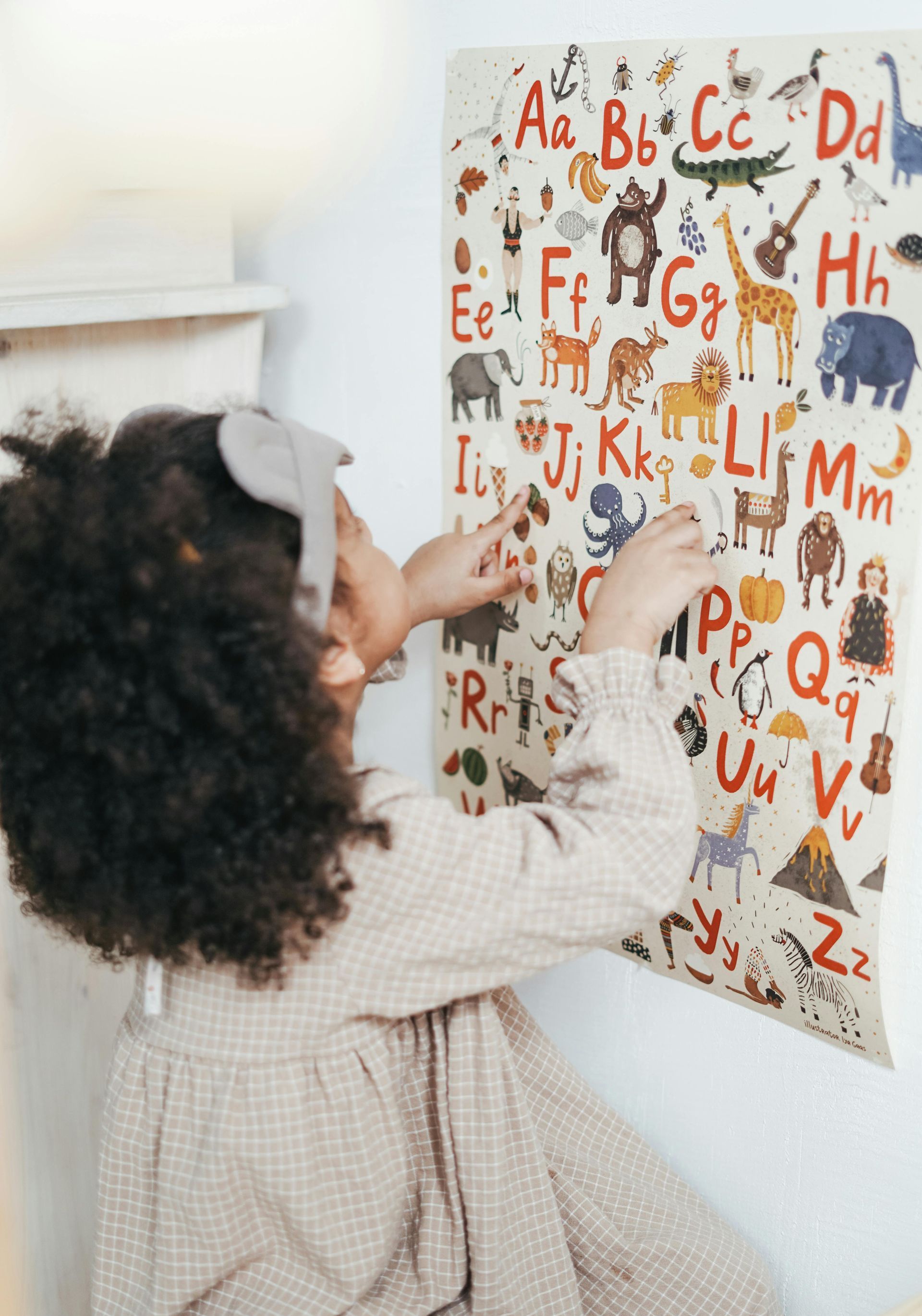 A woman and a little girl are smiling in front of an open book