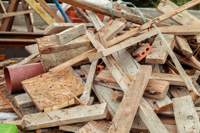 Pile of weathered wooden planks and scrap lumber stacked outdoors