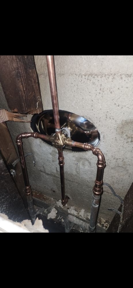 Copper plumbing pipes installed on a concrete wall.