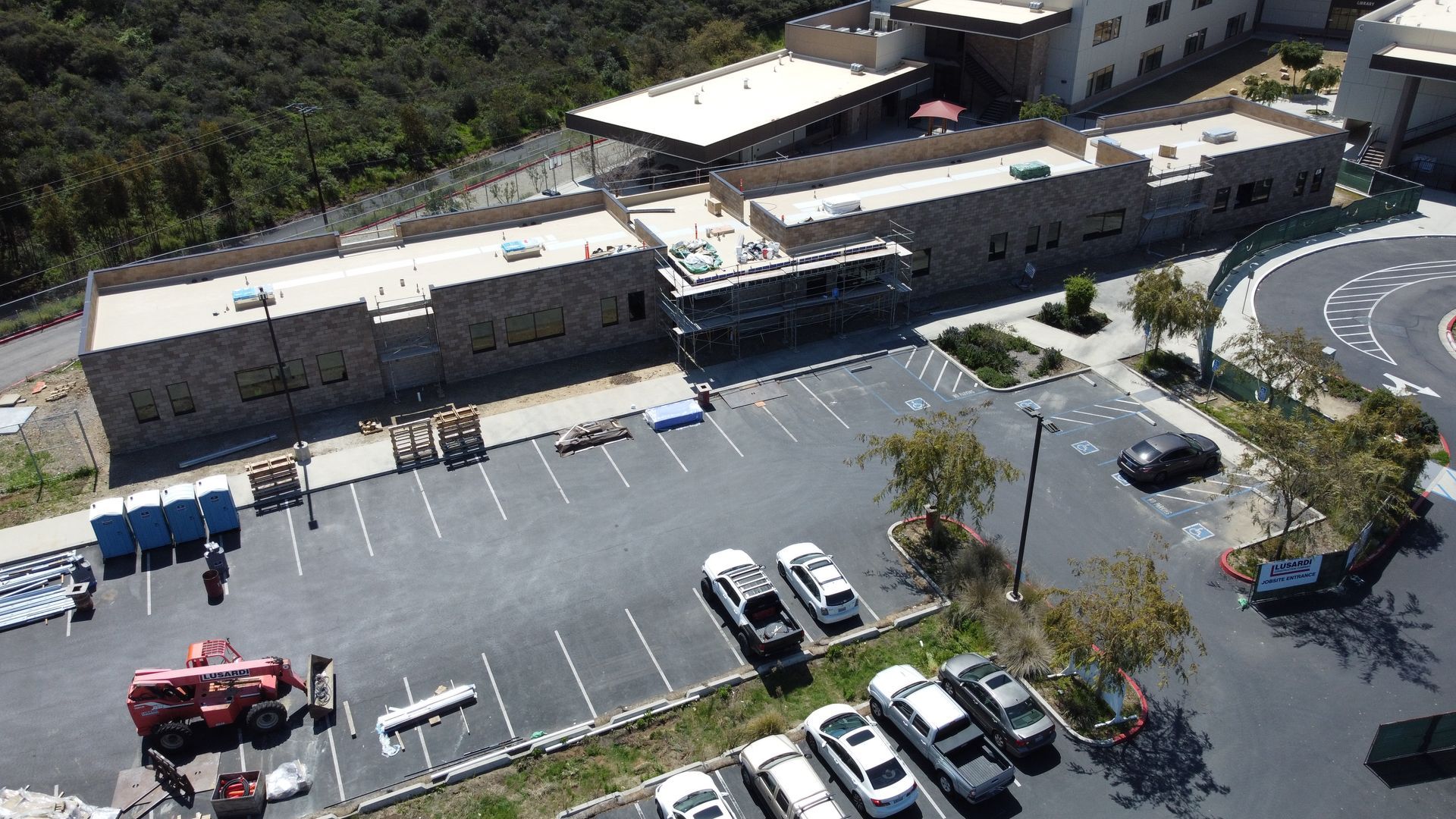 An aerial view of a parking lot with cars parked in front of a building