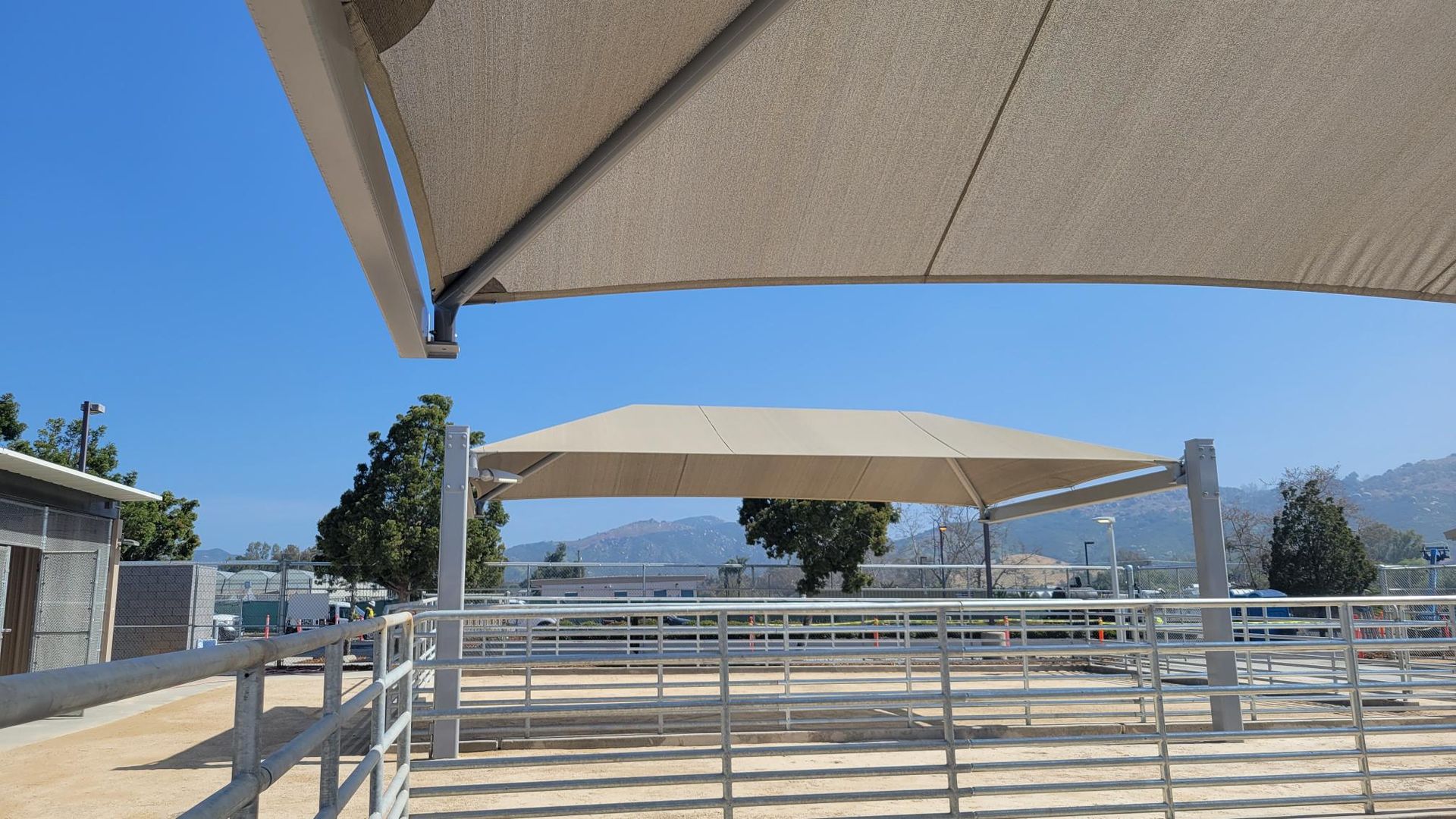 A fenced in area with a large umbrella over it