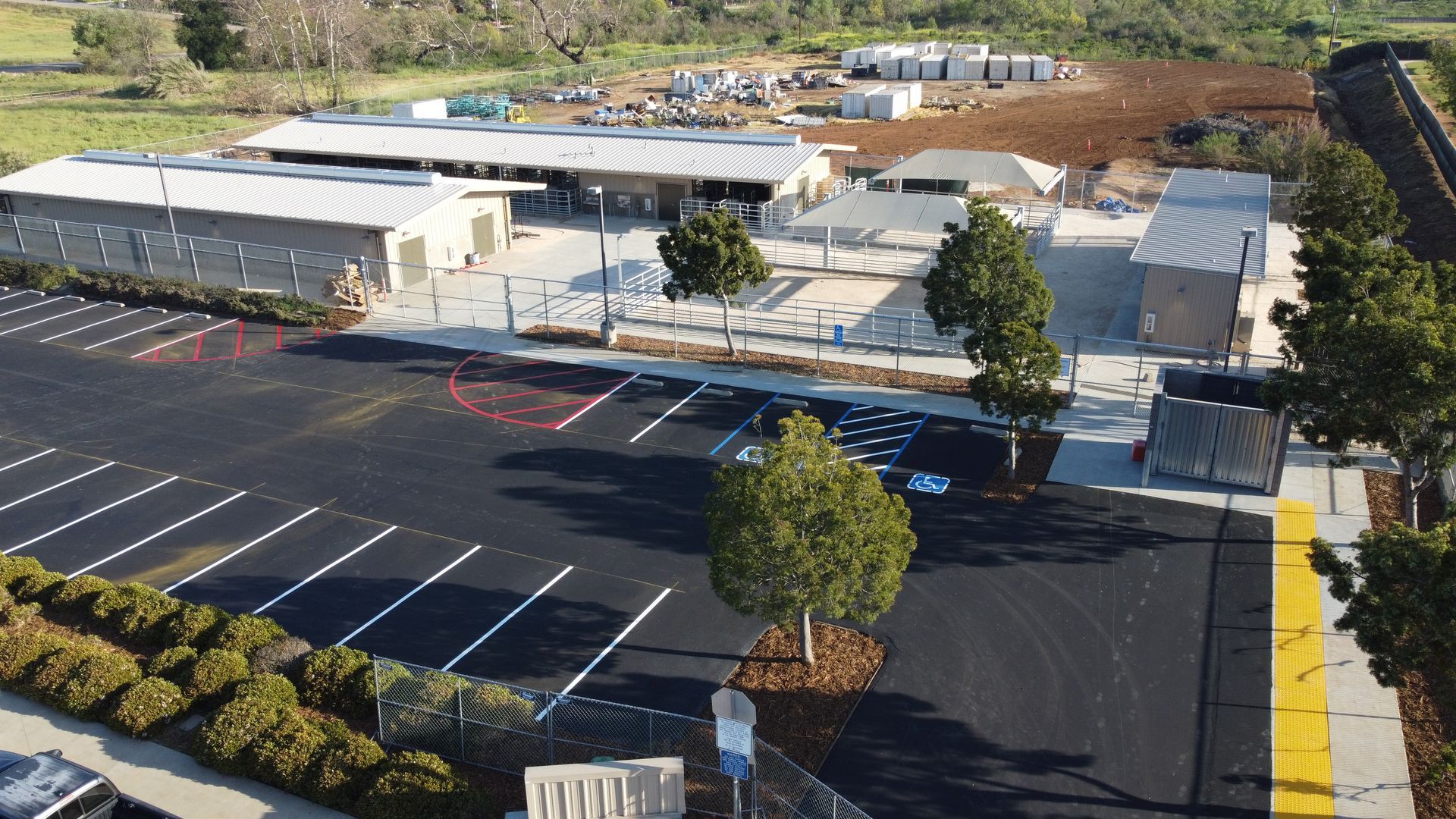 An aerial view of a parking lot with a building in the background