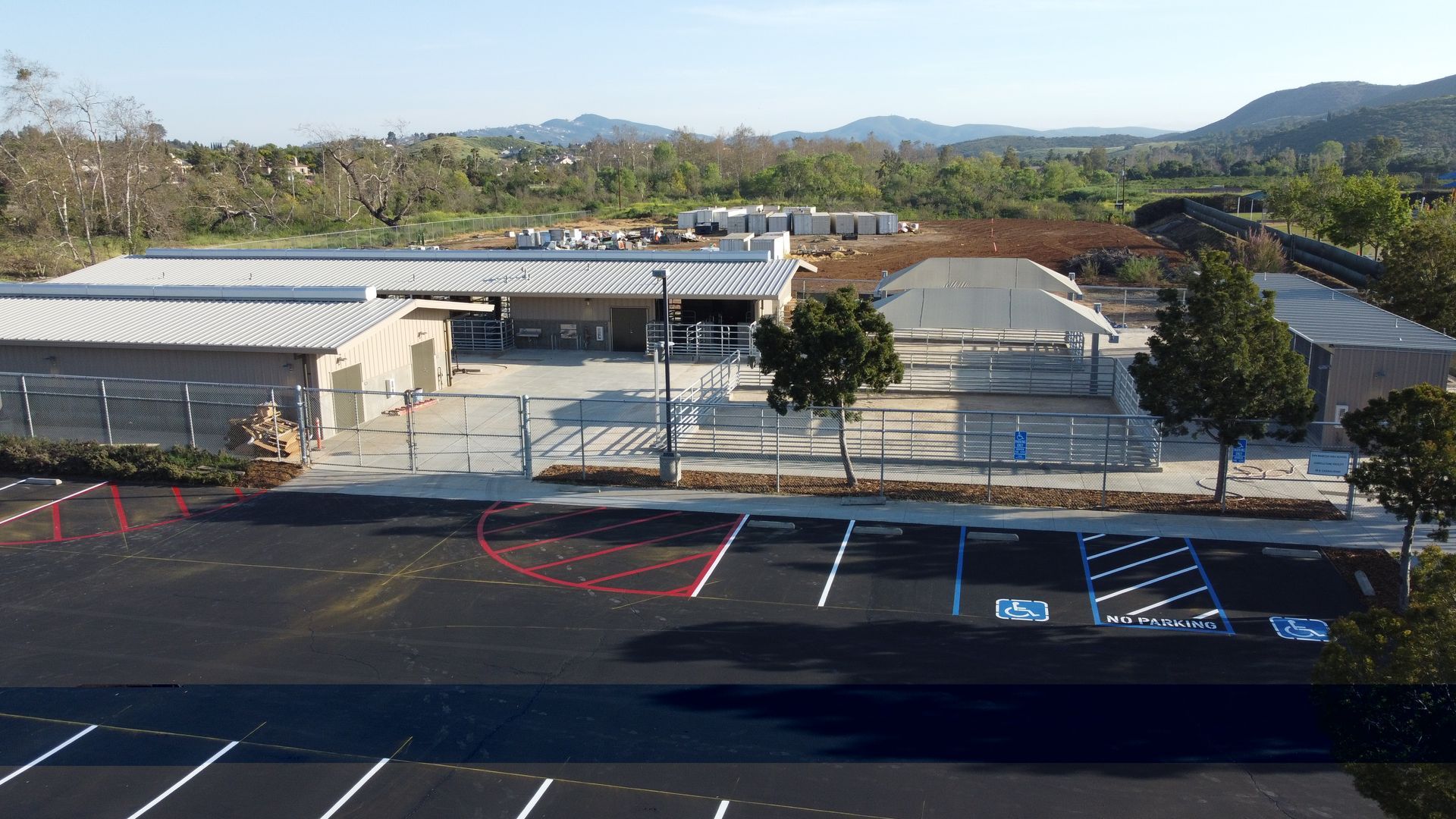 An aerial view of a school with a parking lot in front of it.