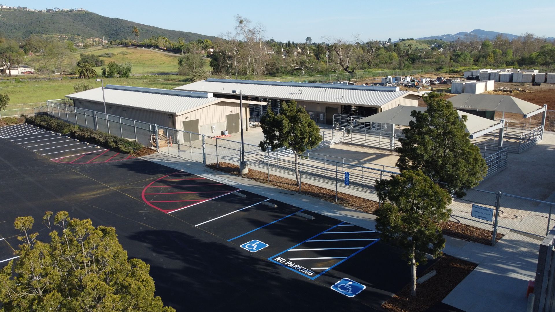 An aerial view of a school with a parking lot in front of it.