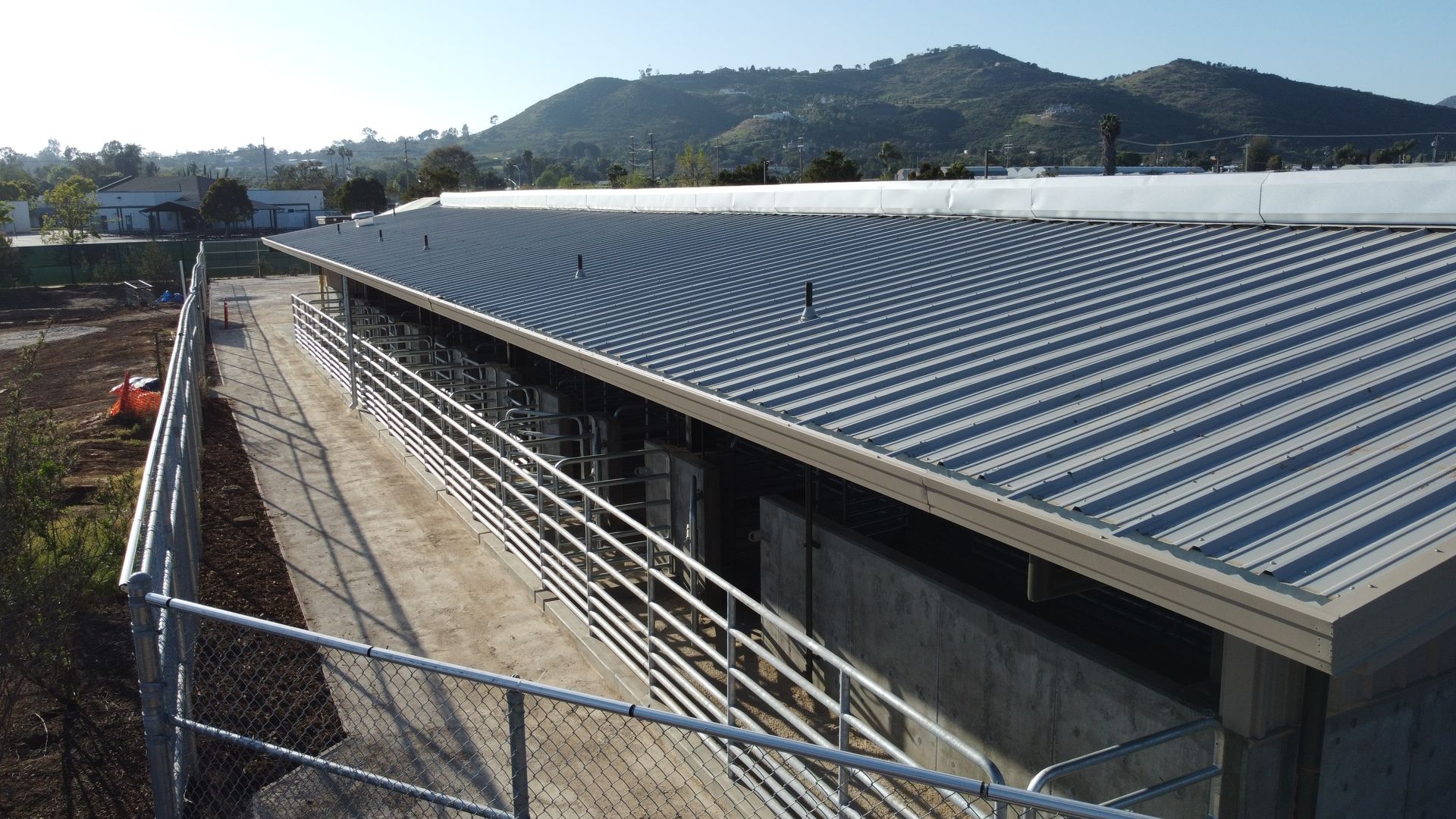 An aerial view of a building with a roof and mountains in the background