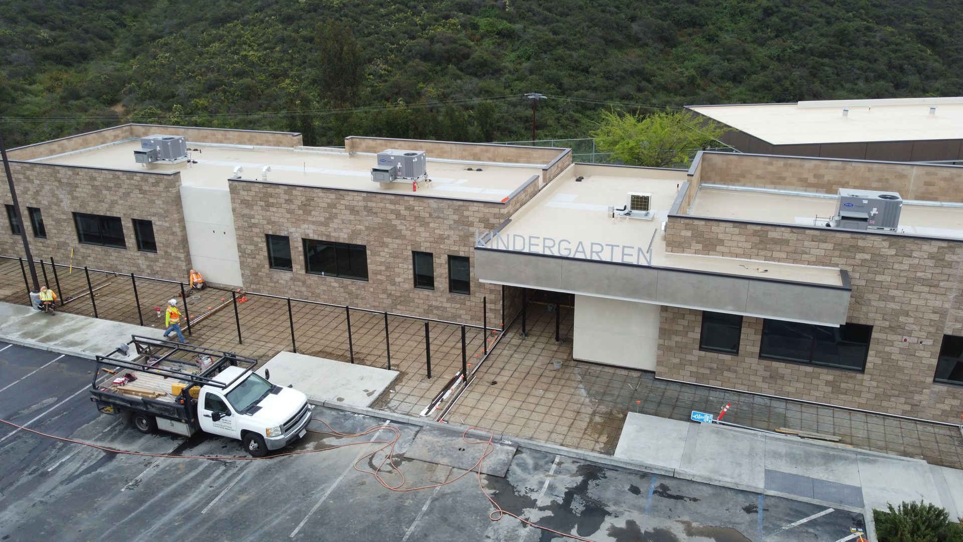 An aerial view of a building under construction with a truck parked in front of it.