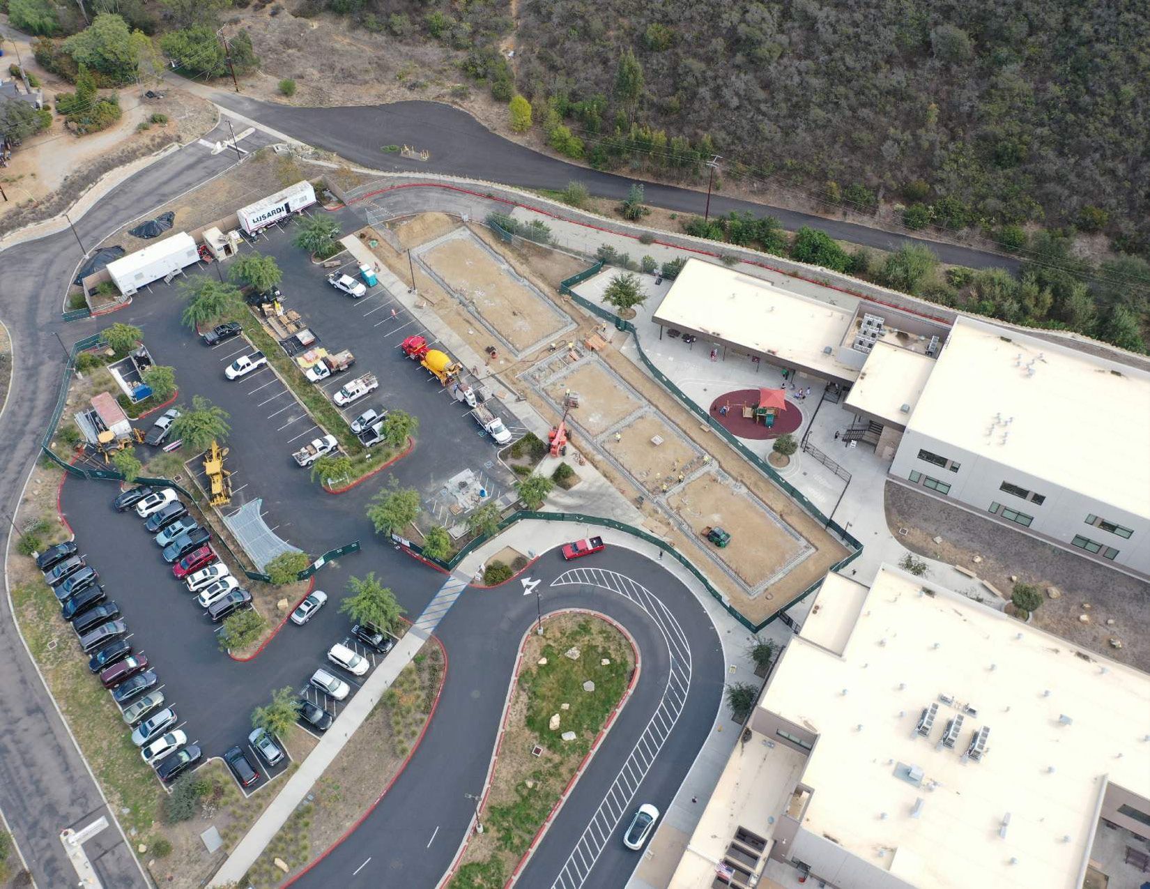 An aerial view of a parking lot with cars parked in it