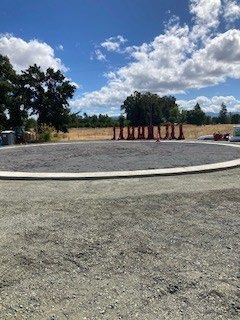 A group of people are standing in a circle in a dirt field.