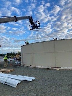 A crane is being used to lift a large tank.