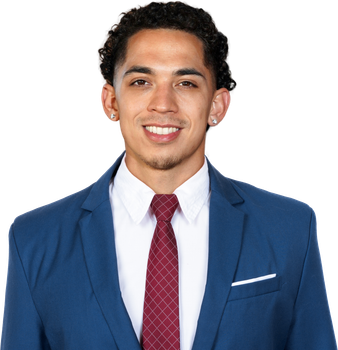 Man in a blue suit with a burgundy tie, smiling with curly dark hair.