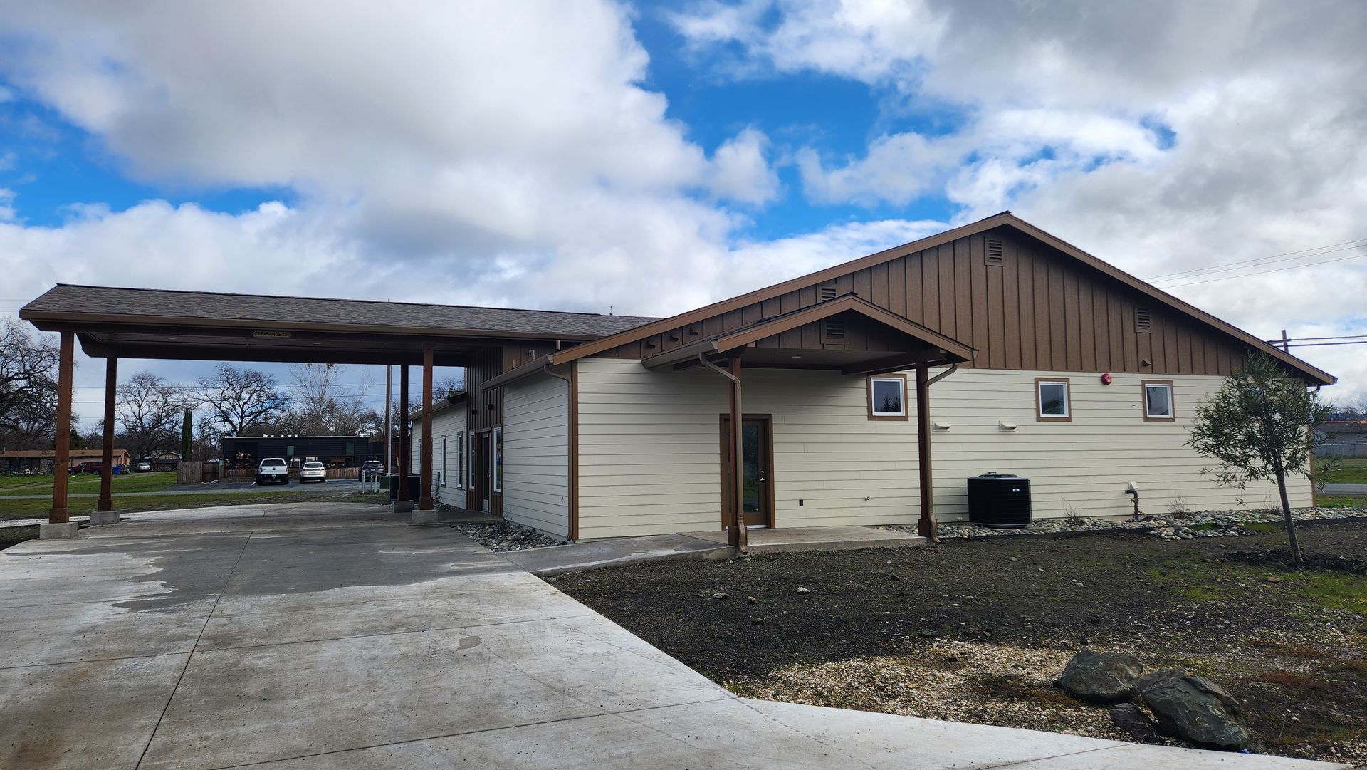 A white house with a brown roof and a driveway